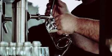 person holding beer mug